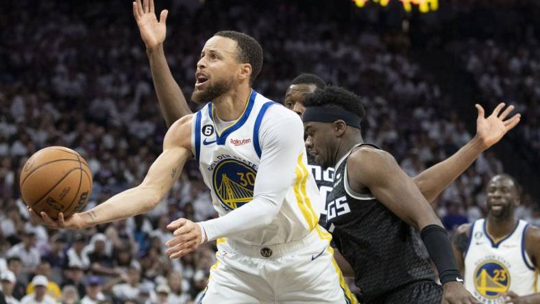 April 30, 2023; Sacramento, California, USA; Golden State Warriors guard Stephen Curry (30) shoots the basketball against Sacramento Kings forward Harrison Barnes (40) and guard Terence Davis (3) during the third quarter in game seven of the 2023 NBA playoffs first round at Golden 1 Center. Mandatory Credit: Kyle Terada-USA TODAY Sports