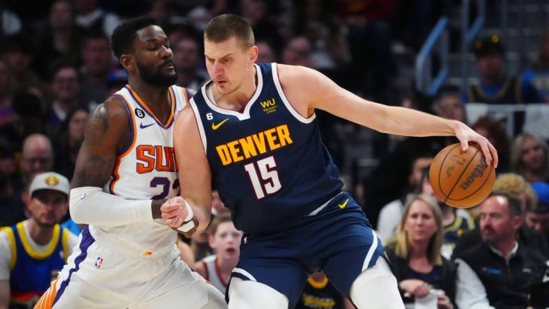 May 1, 2023; Denver, Colorado, USA; Denver Nuggets center Nikola Jokic (15) drives at Phoenix Suns center Deandre Ayton (22) in the first quarter during game two of the 2023 NBA playoffs at Ball Arena. Mandatory Credit: Ron Chenoy-USA TODAY Sports