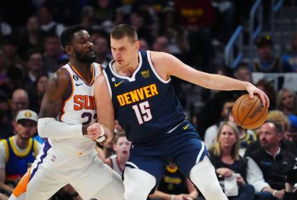 May 1, 2023; Denver, Colorado, USA; Denver Nuggets center Nikola Jokic (15) drives at Phoenix Suns center Deandre Ayton (22) in the first quarter during game two of the 2023 NBA playoffs at Ball Arena. Mandatory Credit: Ron Chenoy-USA TODAY Sports