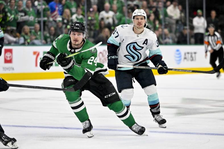 May 2, 2023; Dallas, Texas, USA; Dallas Stars center Roope Hintz (24) and Seattle Kraken center Yanni Gourde (37) chase the puck during the overtime period in game one of the second round of the 2023 Stanley Cup Playoffs at the American Airlines Center. Mandatory Credit: Jerome Miron-USA TODAY Sports