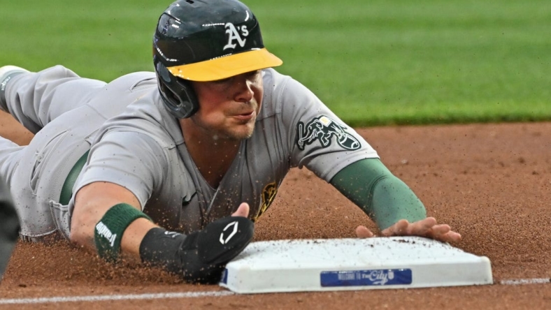 May 5, 2023; Kansas City, Missouri, USA; Oakland Athletics designated hitter Brent Rooker (25) dives into third base after a wild pitch during the first inning against the Kansas City Royals at Kauffman Stadium. Mandatory Credit: Peter Aiken-USA TODAY Sports