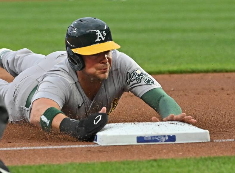 May 5, 2023; Kansas City, Missouri, USA; Oakland Athletics designated hitter Brent Rooker (25) dives into third base after a wild pitch during the first inning against the Kansas City Royals at Kauffman Stadium. Mandatory Credit: Peter Aiken-USA TODAY Sports
