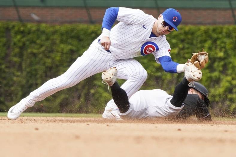 May 6, 2023; Chicago, Illinois, USA; Chicago Cubs second baseman Nico Hoerner (2) tags out Miami Marlins shortstop Jon Berti (5) at second base on a steal attempt of second base during the fifth inning at Wrigley Field. Mandatory Credit: David Banks-USA TODAY Sports