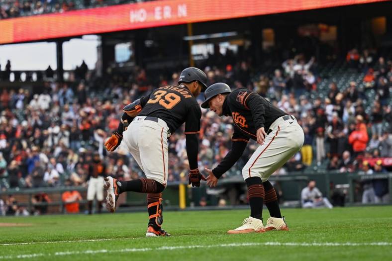 May 6, 2023; San Francisco, California, USA; San Francisco Giants infielder Thairo Estrada (39) shakes hands with third base coach Mark Hallberg (91) after hitting a two-run home run against the Milwaukee Brewers during the third inning at Oracle Park. Mandatory Credit: Robert Edwards-USA TODAY Sports