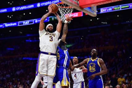 May 6, 2023; Los Angeles, California, USA; Los Angeles Lakers forward Anthony Davis (3) gets the rebound against Golden State Warriors guard Gary Payton II (8) and forward Draymond Green (23) during the second half in game three of the 2023 NBA playoffs at Crypto.com Arena. Mandatory Credit: Gary A. Vasquez-USA TODAY Sports
