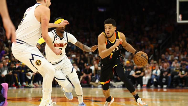 May 7, 2023; Phoenix, Arizona, USA; Phoenix Suns guard Devin Booker (1) against the Denver Nuggets in the first half during game four of the 2023 NBA playoffs at Footprint Center. Mandatory Credit: Mark J. Rebilas-USA TODAY Sports