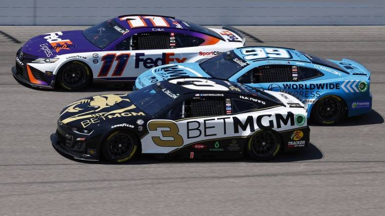 May 7, 2023; Kansas City, Kansas, USA; NASCAR Cup Series driver Denny Hamlin (11), driver Austin Dillon (3) and  driver Daniel Suarez (99) race three wide during the AdventHealth 400 at Kansas Speedway. Mandatory Credit: Mike Dinovo-USA TODAY Sports