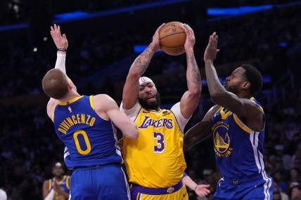 May 8, 2023; Los Angeles, California, USA; Los Angeles Lakers forward Anthony Davis (3) is defended by Golden State Warriors guard Donte DiVincenzo (0) and forward JaMychal Green (1) in the first half during game four of the 2023 NBA playoffs at Crypto.com Arena. Mandatory Credit: Kirby Lee-USA TODAY Sports