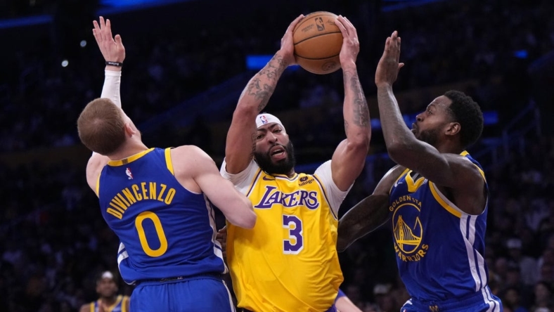 May 8, 2023; Los Angeles, California, USA; Los Angeles Lakers forward Anthony Davis (3) is defended by Golden State Warriors guard Donte DiVincenzo (0) and forward JaMychal Green (1) in the first half during game four of the 2023 NBA playoffs at Crypto.com Arena. Mandatory Credit: Kirby Lee-USA TODAY Sports