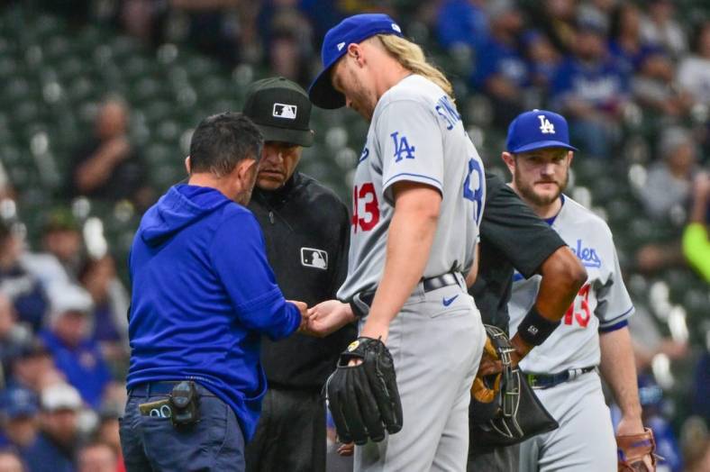 May 9, 2023; Milwaukee, Wisconsin, USA; Los Angeles Dodgers pitcher Noah Syndergaard (43) is checked by a trainer in the first inning during game against the Milwaukee Brewers at American Family Field. Syndergaard later left the game with a possible hand injury. Mandatory Credit: Benny Sieu-USA TODAY Sports