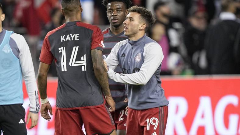 May 9, 2023; Toronto, Ontario, CAN; Toronto FC forward Deandre Kerr (29) and defender Kobe Franklin (19) restrain midfielder Mark-Anthony Kaye (14) after an exchange with a fan following a loss to CF Montreal at BMO Field. Mandatory Credit: John E. Sokolowski-USA TODAY Sports