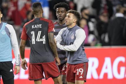 May 9, 2023; Toronto, Ontario, CAN; Toronto FC forward Deandre Kerr (29) and defender Kobe Franklin (19) restrain midfielder Mark-Anthony Kaye (14) after an exchange with a fan following a loss to CF Montreal at BMO Field. Mandatory Credit: John E. Sokolowski-USA TODAY Sports