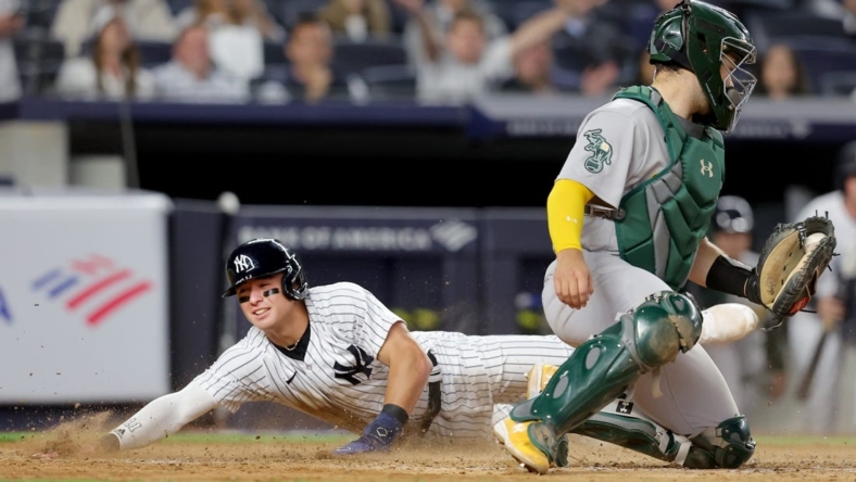 May 9, 2023; Bronx, New York, USA; New York Yankees shortstop Anthony Volpe (11) scores against Oakland Athletics catcher Shea Langeliers (23) on a sacrifice fly by Yankees right fielder Aaron Judge (not pictured) during the eighth inning at Yankee Stadium. Mandatory Credit: Brad Penner-USA TODAY Sports