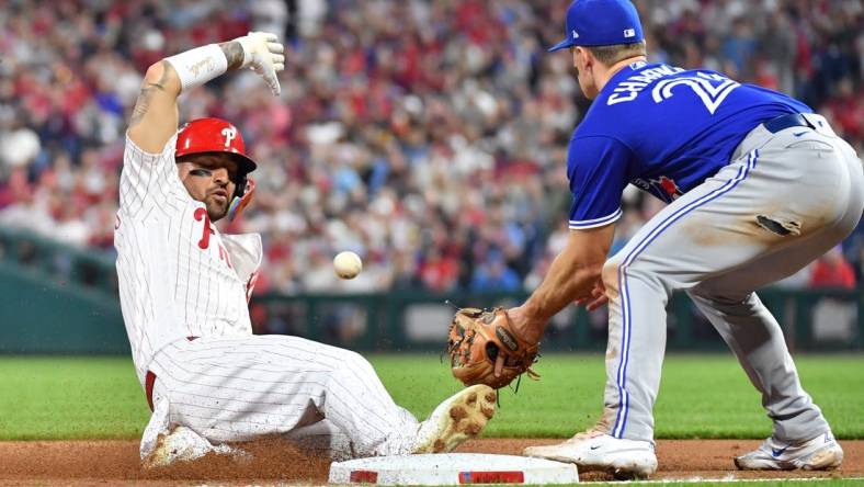 May 9, 2023; Philadelphia, Pennsylvania, USA; Philadelphia Phillies right fielder Nick Castellanos (8) sides safely into third base ahead of tag by Toronto Blue Jays third baseman Matt Chapman (26) during the sixth inning at Citizens Bank Park. Mandatory Credit: Eric Hartline-USA TODAY Sports