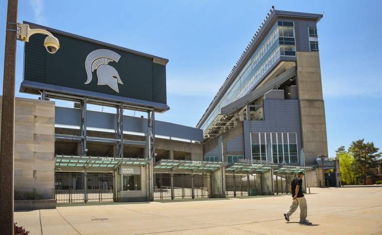 A passerby walks past a camera mounted outside the north entrance of Spartan Stadium, Wednesday, May 10, 2023.
