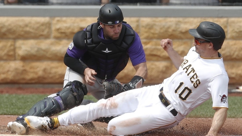 May 10, 2023; Pittsburgh, Pennsylvania, USA;  Colorado Rockies catcher Austin Wynns (16) tags Pittsburgh Pirates left fielder Bryan Reynolds (10) out at home plate attempting to score during the sixth inning at PNC Park. Mandatory Credit: Charles LeClaire-USA TODAY Sports