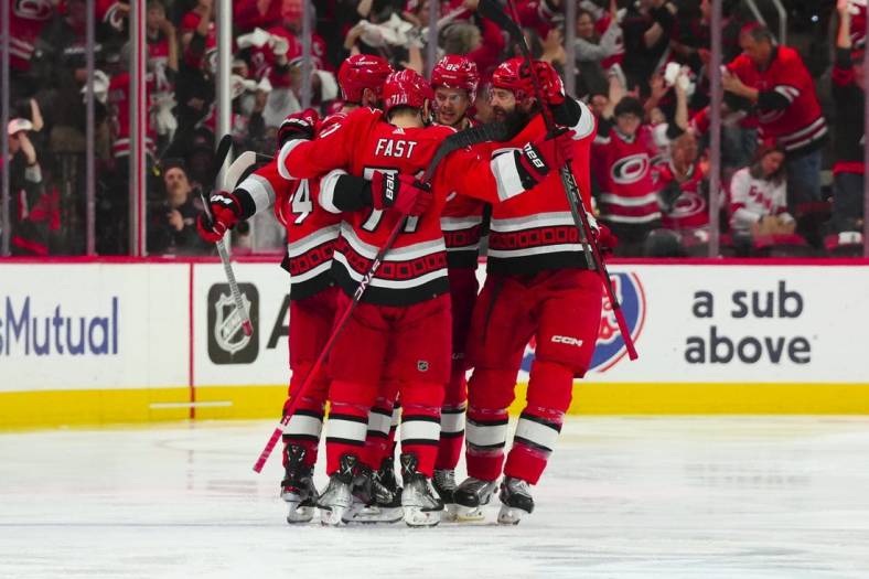 May 11, 2023; Raleigh, North Carolina, USA; Carolina Hurricanes center Jesperi Kotkaniemi (82) is congratulated by right wing Jesper Fast (71) defenseman Brent Burns (8) and defenseman Jaccob Slavin (74) after his goal against the New Jersey Devils during the second period in game five of the second round of the 2023 Stanley Cup Playoffs at PNC Arena. Mandatory Credit: James Guillory-USA TODAY Sports