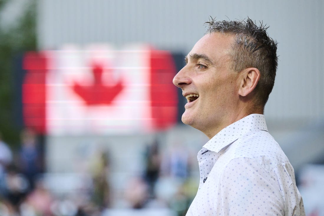 May 13, 2023; Portland, Oregon, USA; Vancouver Whitecaps head coach Vanni Sartini sings along during the a performance of the Canadian National Anthem before a game against the Portland Timbers at Providence Park. Mandatory Credit: Troy Wayrynen-USA TODAY Sports