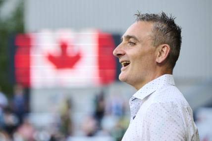 May 13, 2023; Portland, Oregon, USA; Vancouver Whitecaps head coach Vanni Sartini sings along during the a performance of the Canadian National Anthem before a game against the Portland Timbers at Providence Park. Mandatory Credit: Troy Wayrynen-USA TODAY Sports