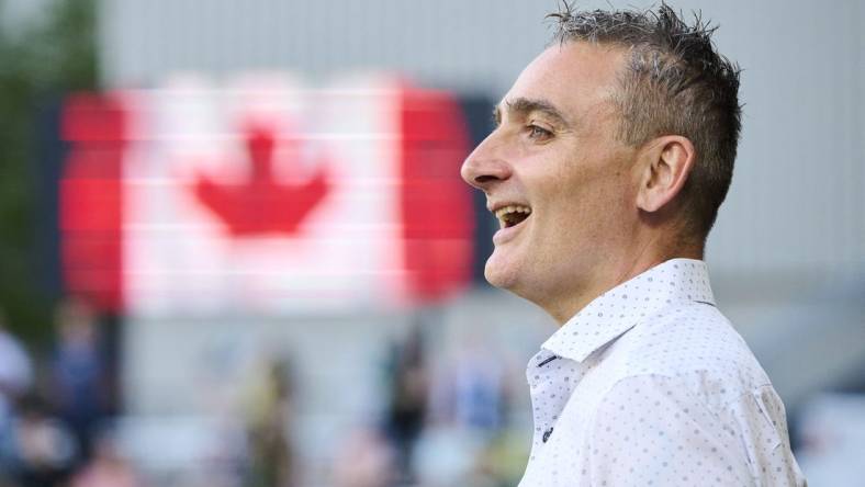 May 13, 2023; Portland, Oregon, USA; Vancouver Whitecaps head coach Vanni Sartini sings along during the a performance of the Canadian National Anthem before a game against the Portland Timbers at Providence Park. Mandatory Credit: Troy Wayrynen-USA TODAY Sports