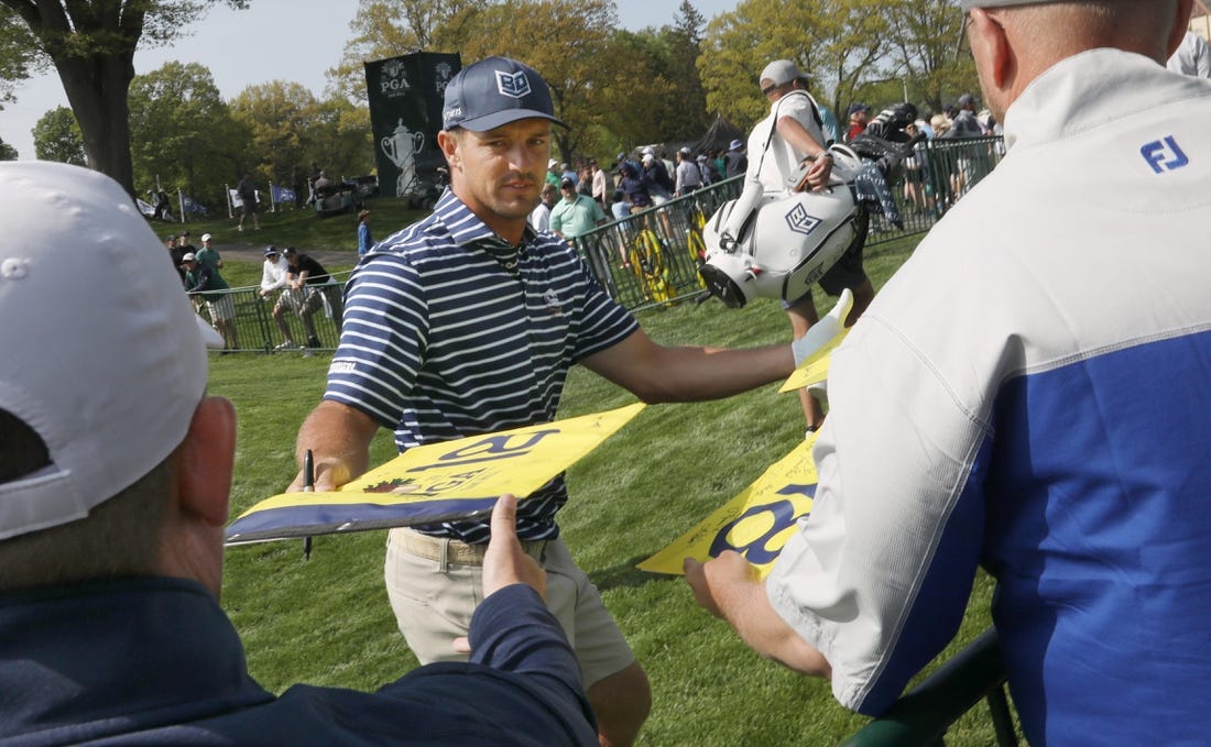 Bryson DeChambeau signs autographs for fans as he leaves the practice range before staring his practice round at the PGA Championship at Oak Hill Country Club Monday, May 15, 2023.