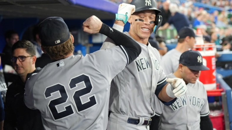 May 15, 2023; Toronto, Ontario, CAN; New York Yankees right fielder Aaron Judge (99) celebrates in the dugout with center fielder Harrison Bader (22) after hitting a home run against the Toronto Blue Jays during the eighth inning at Rogers Centre. Mandatory Credit: Nick Turchiaro-USA TODAY Sports