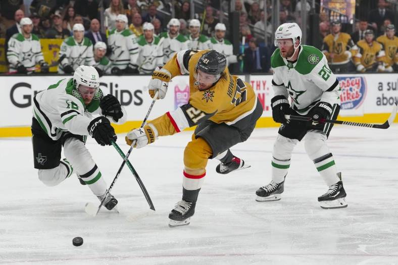 May 19, 2023; Las Vegas, Nevada, USA; Vegas Golden Knights center Brett Howden (21) shoots the puck past Dallas Stars center Radek Faksa (12) and defenseman Ryan Suter (20) during the first period in game one of the Western Conference Finals of the 2023 Stanley Cup Playoffs at T-Mobile Arena. Mandatory Credit: Stephen R. Sylvanie-USA TODAY Sports