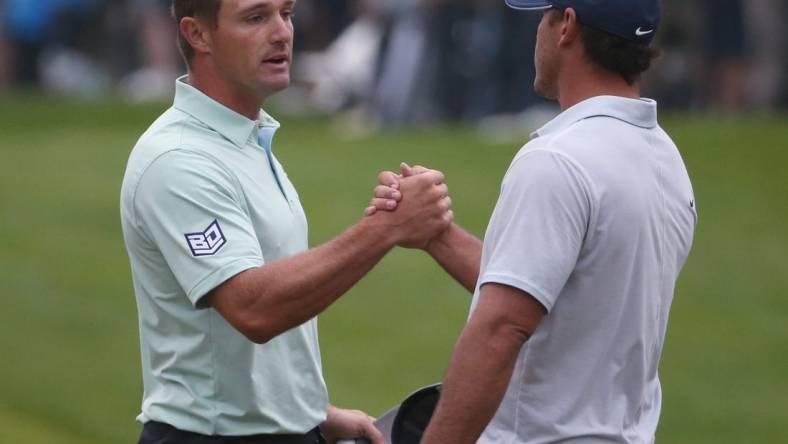 Playing partners Bryson DeChambeau and Brooks Koepka shake hands at the 18th hole following their third round at the PGA Championship at Oak Hill Country Club Saturday, May 20, 2023.  Koepka finished the day in the lead at -6, while DeChambeau finished the day in fourth at -3.