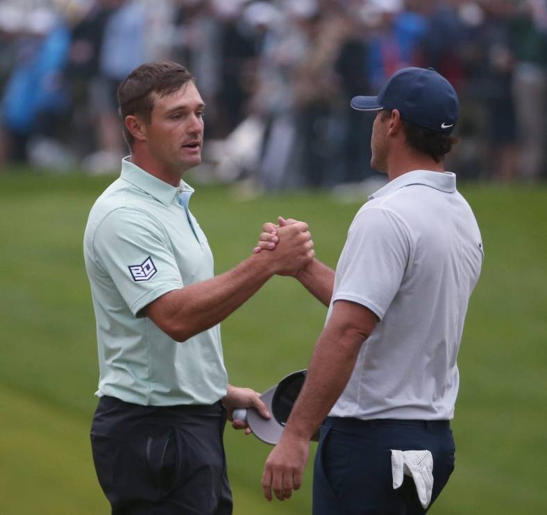 Playing partners Bryson DeChambeau and Brooks Koepka shake hands at the 18th hole following their third round at the PGA Championship at Oak Hill Country Club Saturday, May 20, 2023.  Koepka finished the day in the lead at -6, while DeChambeau finished the day in fourth at -3.