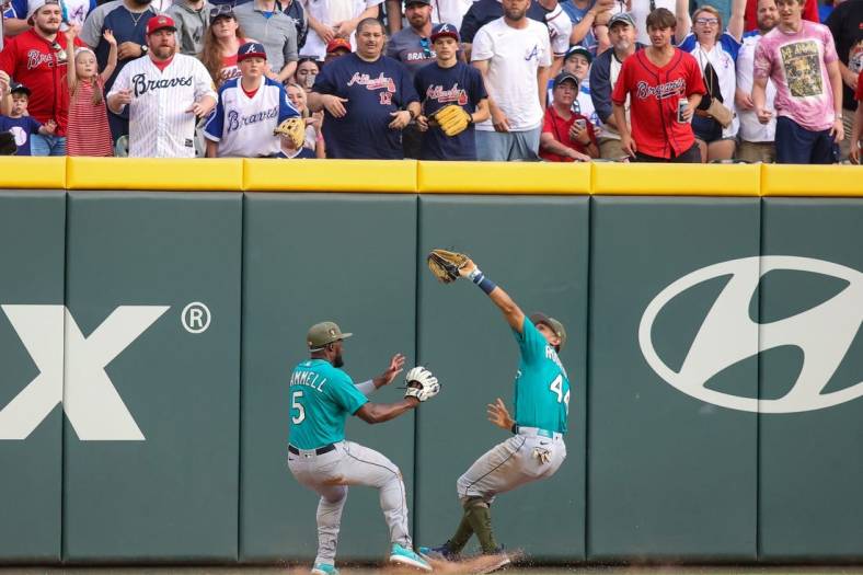 May 20, 2023; Atlanta, Georgia, USA; Seattle Mariners center fielder Julio Rodriguez (44) collides with left fielder Taylor Trammell (5) after a catch against the Atlanta Braves in the second inning at Truist Park. Mandatory Credit: Brett Davis-USA TODAY Sports