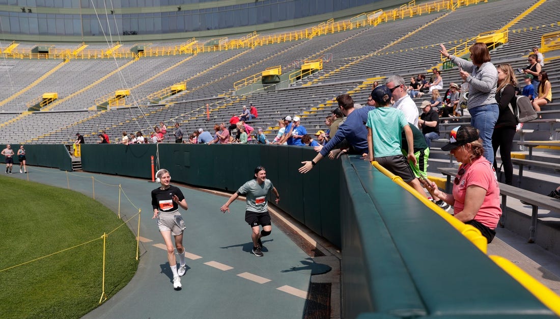 Participants runs through Lambeau Field during the 2023 Cellcom Green Bay Marathon on May 21, 2023, in Green Bay, Wis.