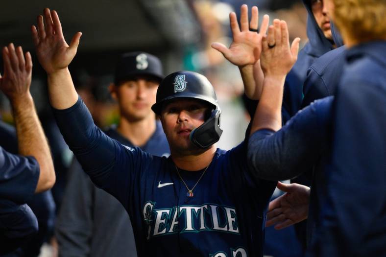 May 22, 2023; Seattle, Washington, USA; Seattle Mariners first baseman Ty France (23) celebrates in the dugout after scoring a run off a single hit by third baseman Eugenio Suarez (28) during the sixth inning against the Oakland Athletics at T-Mobile Park. Mandatory Credit: Steven Bisig-USA TODAY Sports