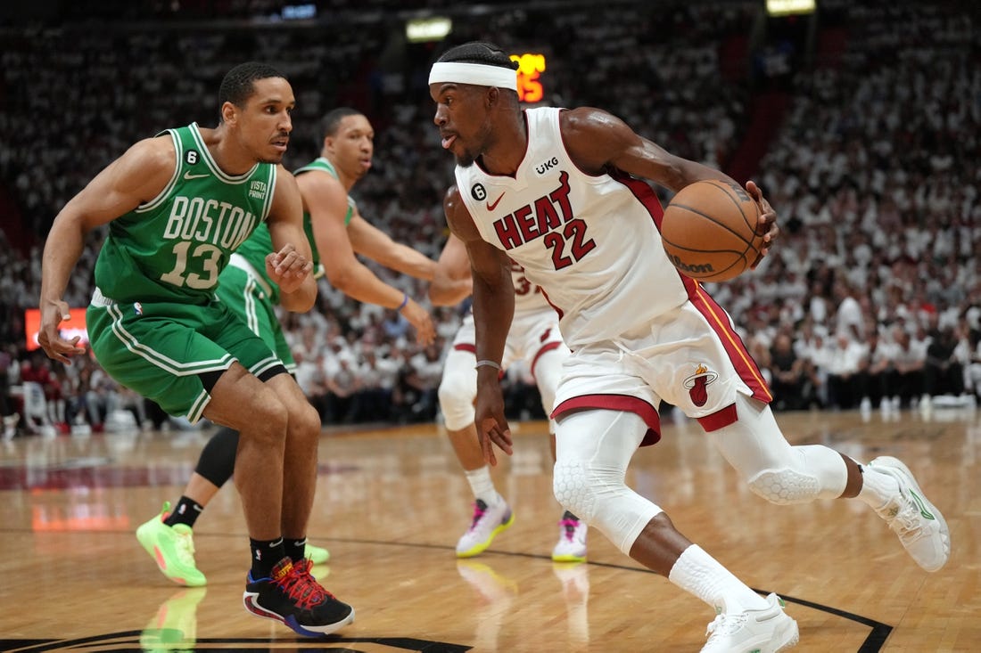 May 23, 2023; Miami, Florida, USA; Miami Heat forward Jimmy Butler (22) controls the ball against Boston Celtics guard Malcolm Brogdon (13) in the first quarter during game four of the Eastern Conference Finals for the 2023 NBA playoffs at Kaseya Center. Mandatory Credit: Jim Rassol-USA TODAY Sports