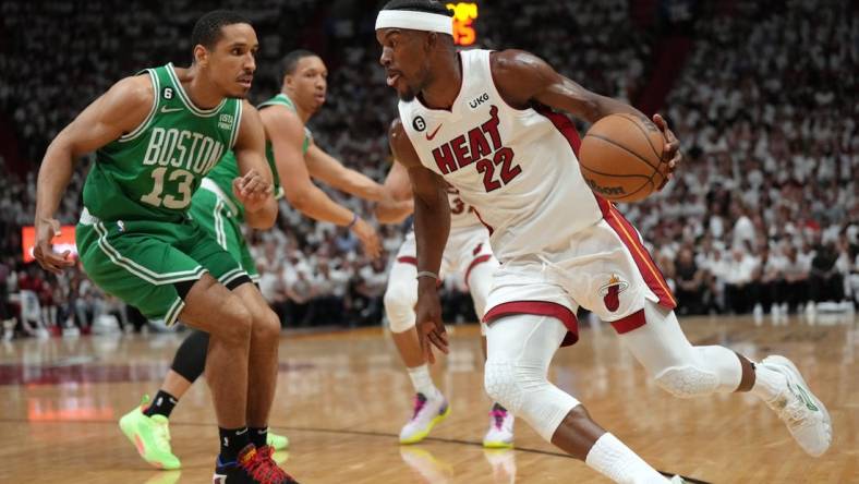 May 23, 2023; Miami, Florida, USA; Miami Heat forward Jimmy Butler (22) controls the ball against Boston Celtics guard Malcolm Brogdon (13) in the first quarter during game four of the Eastern Conference Finals for the 2023 NBA playoffs at Kaseya Center. Mandatory Credit: Jim Rassol-USA TODAY Sports