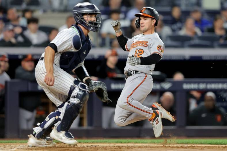 May 25, 2023; Bronx, New York, USA; Baltimore Orioles second baseman Adam Frazier (12) scores in front of New York Yankees catcher Ben Rortvedt (38) on an RBI single by Orioles right fielder Anthony Santander (not pictured) during the fifth inning at Yankee Stadium. Mandatory Credit: Brad Penner-USA TODAY Sports