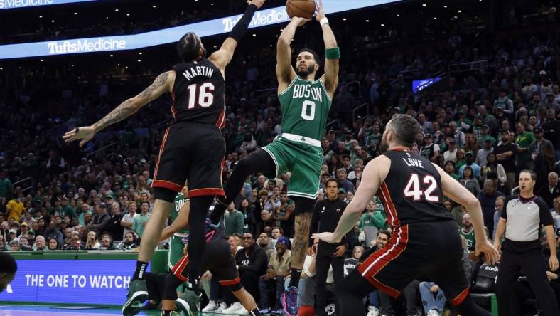 May 25, 2023; Boston, Massachusetts, USA; Boston Celtics forward Jayson Tatum (0) shoots against Miami Heat forward Caleb Martin (16) and forward Kevin Love (42) during the fourth quarter of game five of the Eastern Conference Finals for the 2023 NBA playoffs at TD Garden. Mandatory Credit: Winslow Townson-USA TODAY Sports