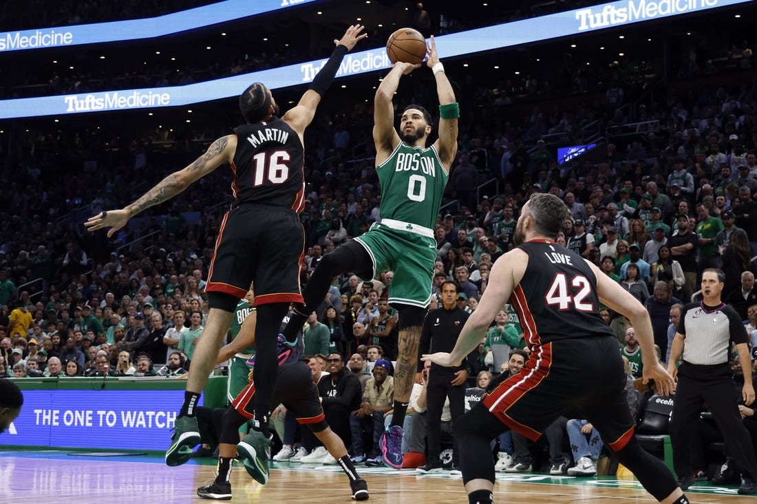 May 25, 2023; Boston, Massachusetts, USA; Boston Celtics forward Jayson Tatum (0) shoots against Miami Heat forward Caleb Martin (16) and forward Kevin Love (42) during the fourth quarter of game five of the Eastern Conference Finals for the 2023 NBA playoffs at TD Garden. Mandatory Credit: Winslow Townson-USA TODAY Sports