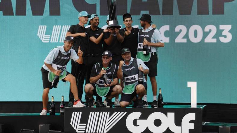 May 28, 2023; Potomac Falls, Virginia, USA; Members of Team Torque celebrate on the podium after winning the team championship of LIV Golf Washington, D.C. golf tournament at Trump National. Mandatory Credit: Geoff Burke-USA TODAY Sports