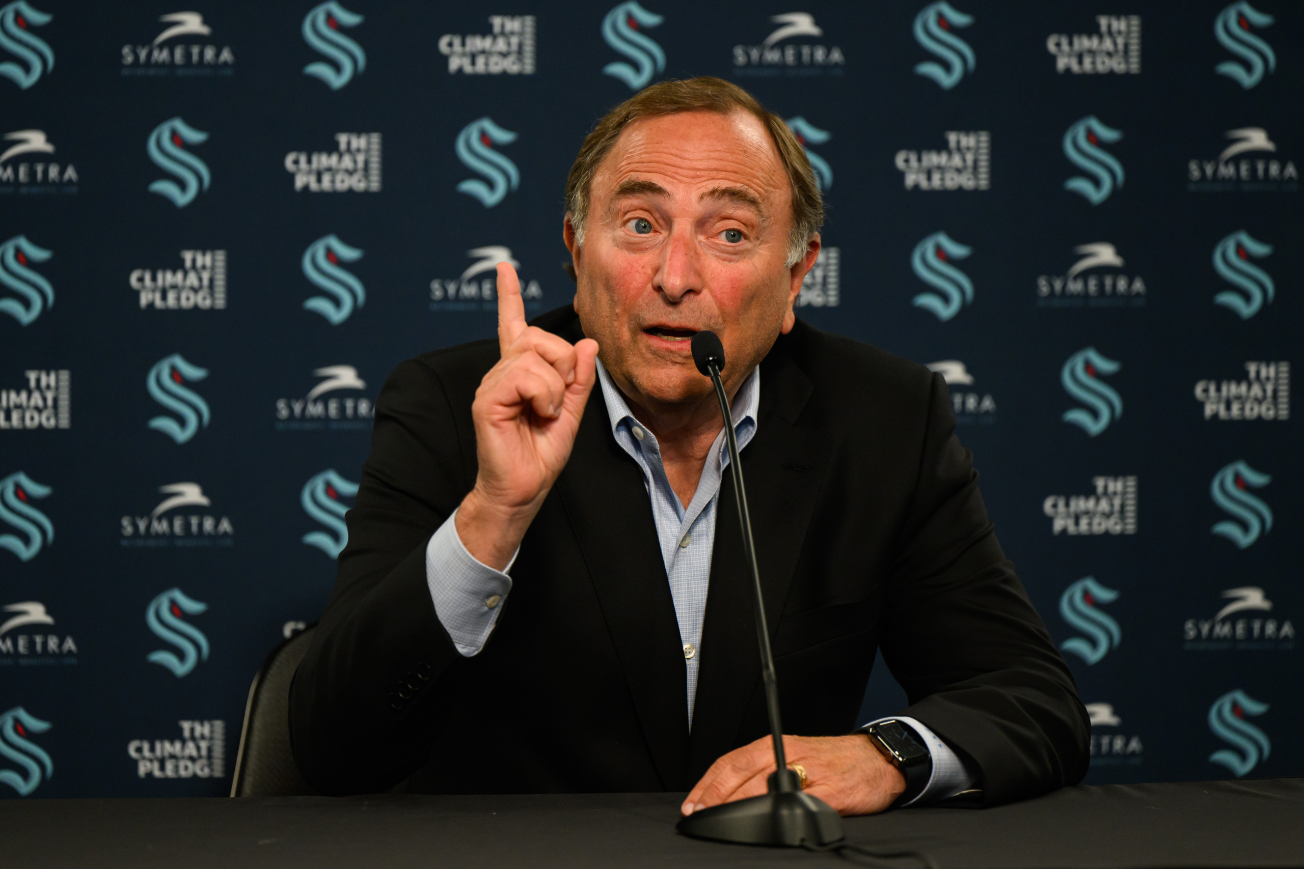 NHL Commissioner Gary Bettman (R) listens to a question during a