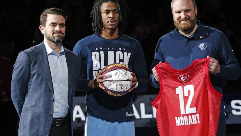 Feb 16, 2022; Memphis, Tennessee, USA; Memphis Grizzles guard Ja Morant (middle) receives a memorial game ball and jersey from general manager Zach Kleiman (left) and head coach Taylor Jenkins, for being selected to the All-Star Game, at FedExForum. Mandatory Credit: Petre Thomas-USA TODAY Sports