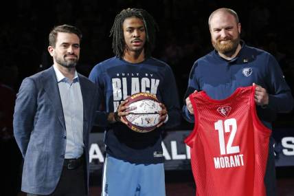 Feb 16, 2022; Memphis, Tennessee, USA; Memphis Grizzles guard Ja Morant (middle) receives a memorial game ball and jersey from general manager Zach Kleiman (left) and head coach Taylor Jenkins, for being selected to the All-Star Game, at FedExForum. Mandatory Credit: Petre Thomas-USA TODAY Sports