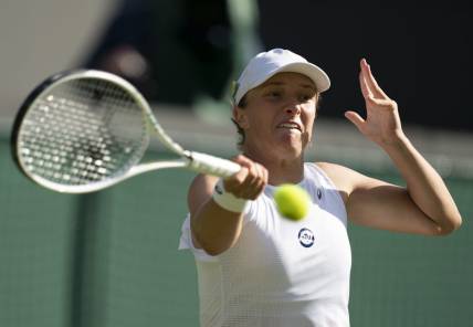 Jun 30, 2022; London, United Kingdom; Iga Swiatek (POL) returns a shot during her match against Lesley Pattinama Kerkhove (NED) on day four at All England Lawn Tennis and Croquet Club. Mandatory Credit: Susan Mullane-USA TODAY Sports