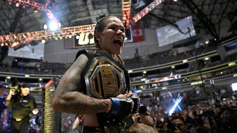 Jul 30, 2022; Dallas, TX, USA; Amanda Nunes (blue gloves) reacts after defeating Julianna Pena (not pictured) in a women   s bantamweight title bout during UFC 277 at the American Airlines Center. Mandatory Credit: Jerome Miron-USA TODAY Sports