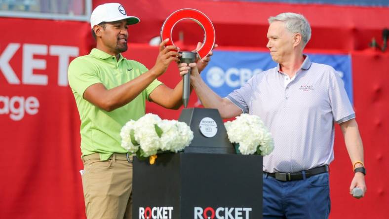 Tony Finau receives the 2022 Rocket Mortgage Classic trophy in joy after winning at the Detroit Golf Club last year. 

Rocket Mortgage Classic