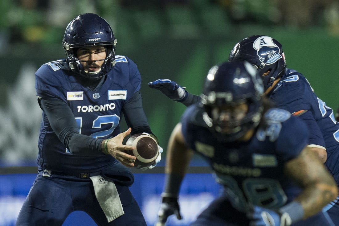 Nov 20, 2022; Regina, Saskatchewan, CAN; Toronto Argonauts quarterback Chad Kelly (12) hands the ball off to running back Andrew Harris (33) against the Winnipeg Blue Bombers in the second half. The Argonauts defeated the Blue Bombers to win the 2022 Grey Cup Championship at Mosaic Stadium. Toronto won 24-23. Mandatory Credit: Bob Frid-USA TODAY Sports