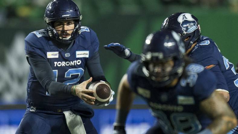 Nov 20, 2022; Regina, Saskatchewan, CAN; Toronto Argonauts quarterback Chad Kelly (12) hands the ball off to running back Andrew Harris (33) against the Winnipeg Blue Bombers in the second half. The Argonauts defeated the Blue Bombers to win the 2022 Grey Cup Championship at Mosaic Stadium. Toronto won 24-23. Mandatory Credit: Bob Frid-USA TODAY Sports