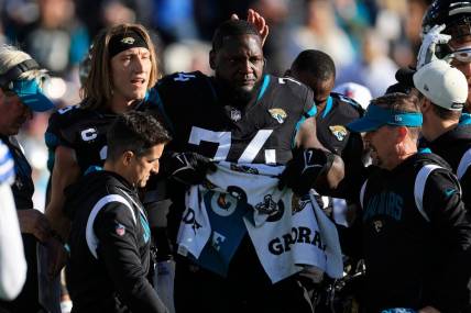 Jacksonville Jaguars offensive lineman Cam Robinson (74) tears up after an apparent injury as quarterback Trevor Lawrence (16) pats him on the head during the fourth quarter of a regular season NFL football matchup Sunday, Dec. 18, 2022 at TIAA Bank Field in Jacksonville. The Jacksonville Jaguars edged the Dallas Cowboys 40-34 in overtime.

Pom Dec 09