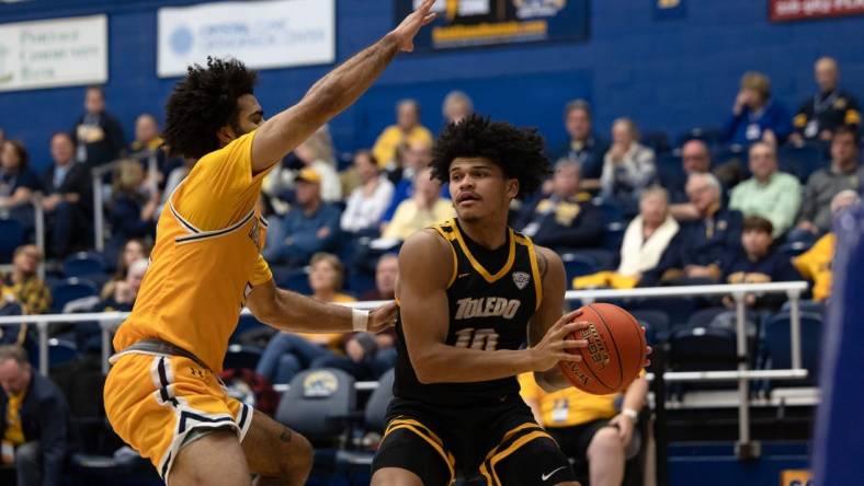 Toledo guard RayJ Dennis looks for an open teammate under the basket while being guarded by Kent State guard Sincere Carry during an NCAA basketball game, Tuesday, Jan. 10, 2023 at the Kent State M.A.C. Center.

University Of Toledo Rockets At Kent State Golden Flashes Ncaa Men S Basketball