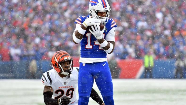 Jan 22, 2023; Orchard Park, New York, USA; Buffalo Bills wide receiver Stefon Diggs (14) makes a catch while defended by Cincinnati Bengals cornerback Cam Taylor-Britt (29) during the first quarter of an AFC divisional round game at Highmark Stadium. Mandatory Credit: Mark Konezny-USA TODAY Sports