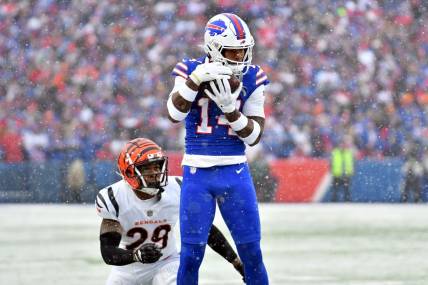 Jan 22, 2023; Orchard Park, New York, USA; Buffalo Bills wide receiver Stefon Diggs (14) makes a catch while defended by Cincinnati Bengals cornerback Cam Taylor-Britt (29) during the first quarter of an AFC divisional round game at Highmark Stadium. Mandatory Credit: Mark Konezny-USA TODAY Sports